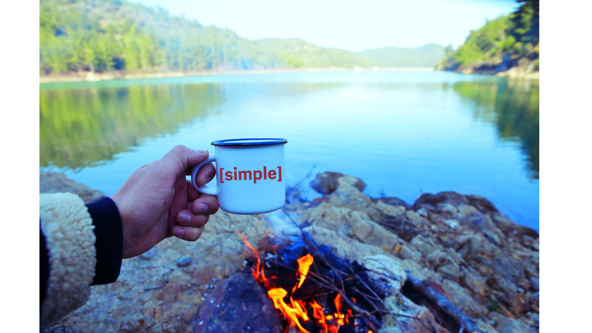 Bonfire and STS coffee mug, overlooking a body of water.